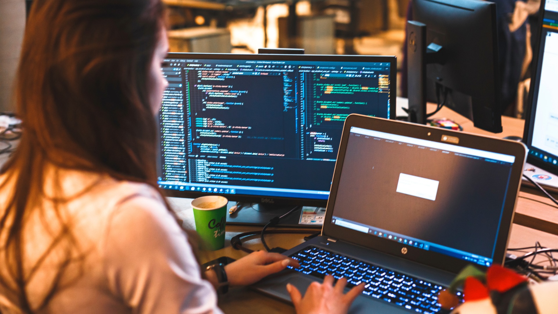 A developer coding on a bank of monitors